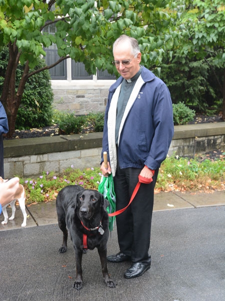 Msgr. Paul A. Litwin keeps an eye on Timon, Bishop Richard Malone's dog, during the blessing of pets outside the bishop's residence to honor the feast of St. Francis of Assisi. 
(Patrick McPartland/Staff Photographer)