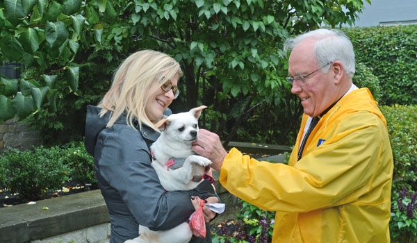 Bishop Richard J. Malone blesses Annabelle while being held by Jessica Tojek outside his residence to honor the feast of St. Francis of Assisi. 
(Patrick McPartland/Staff Photographer)