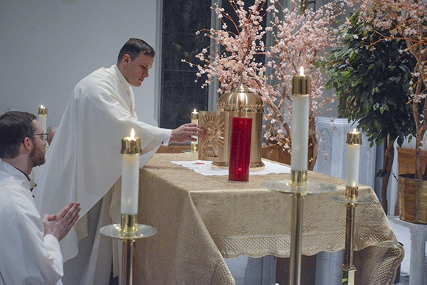 Father Ryszard Biernat locks the tabernacle after the Blessed Sacrament is transferred to the Mary Chapel at St. Joseph Cathedral during Evening Mass of the Lord's Supper. (Patrick McPartland/Managing Editor)