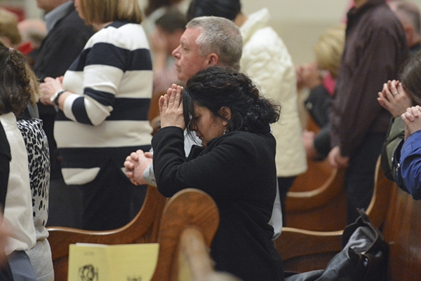 A woman kneels in prayer after Communion at St. Joseph Cathedral during Evening Mass of the Lord's Supper. (Patrick McPartland/Managing Editor)