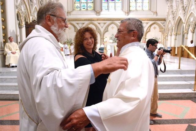 Deacon Ted Pijacki (from left) and Karen Birmingham help newly ordained deacon Edward Birmingham with his stole and dalmatic during the Ordination of Deacons at St. Joseph Cathedral Sept. 16. (Patrick McPartland/Managing Editor)