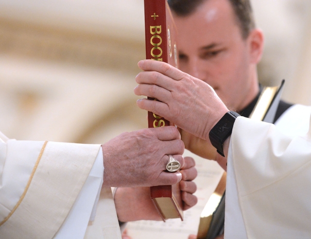 Bishop Richard J. Malone (left) hands the Book of the Gospels to Gerard Skrzynski during the ordination of deacons at St. Joseph Cathedral Sept. 16. The bishop presented the Book of the Gospels as a sign of the deacon's mission. (Patrick McPartland/Managing Editor)